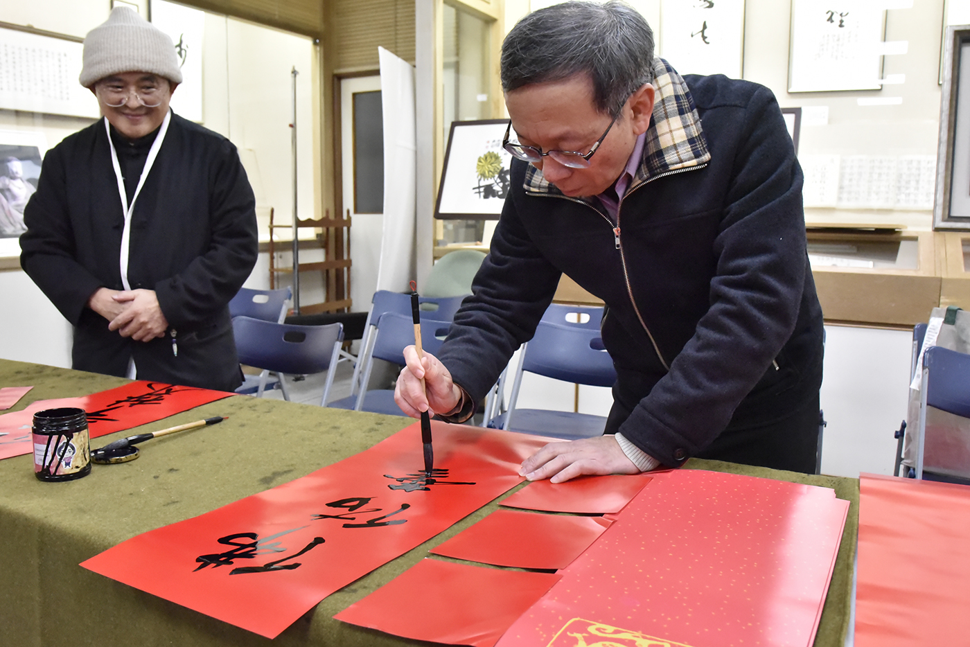 簡江儒教務長（右）於春聯活動現場揮毫，與佛教藝術學系吳大仁老師同寫「佛佑華梵」。