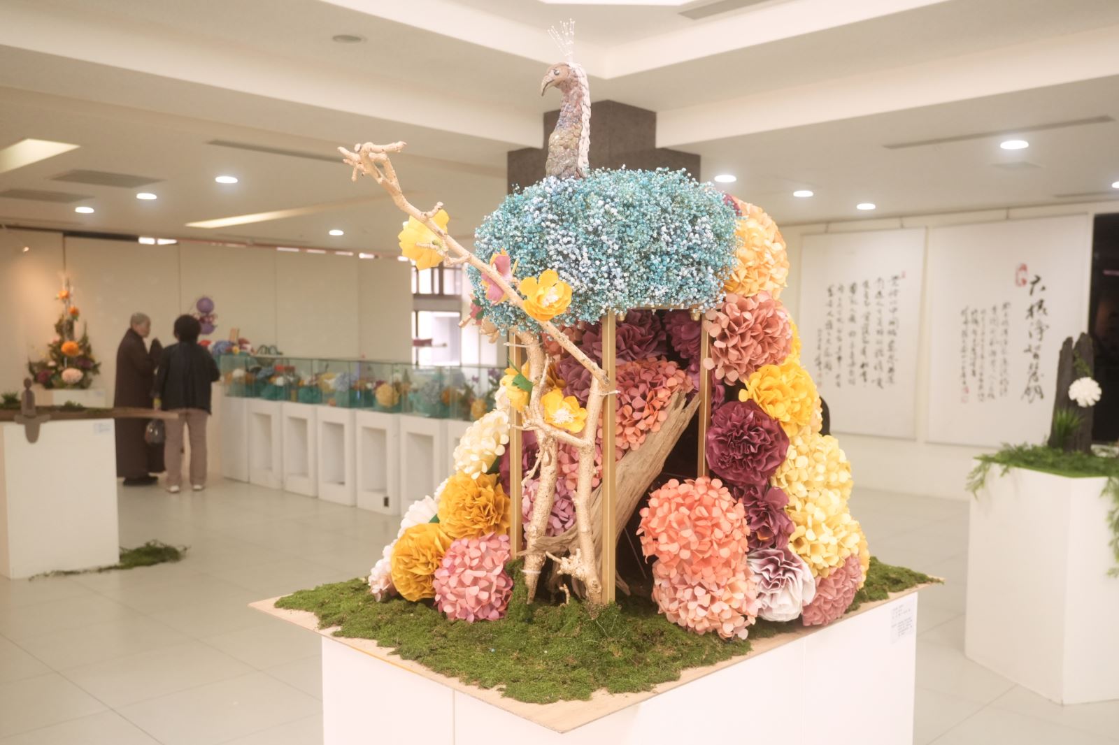 華梵大學佛教紙花工藝課第三組同學作品〈孔雀呈祥〉在現場中央引人注目。