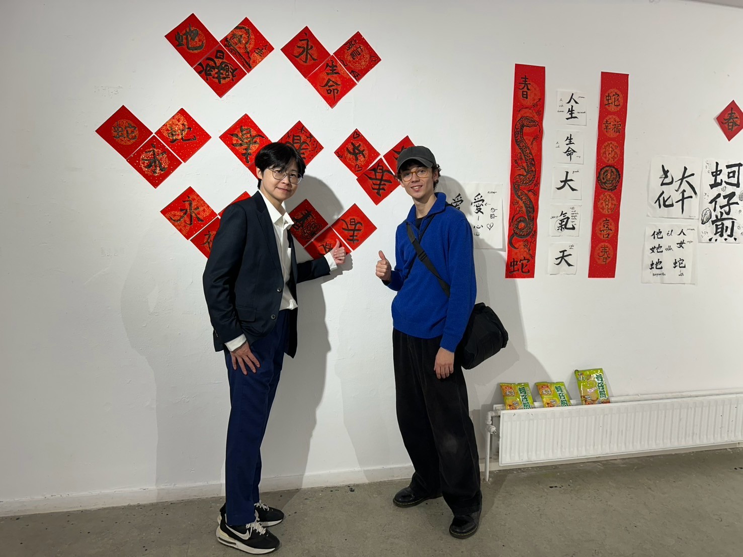 華梵大學教授藝術家楊侖（左）與西班牙學生在書法作品前合影。