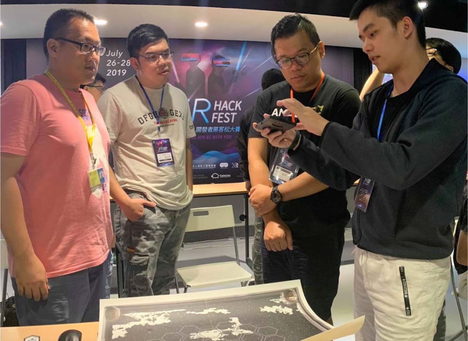 黃聖為同學(右一) 向AMD虛擬實境暨顯示部總監盧英瑞(右二)解說最終版本的AR系統功能