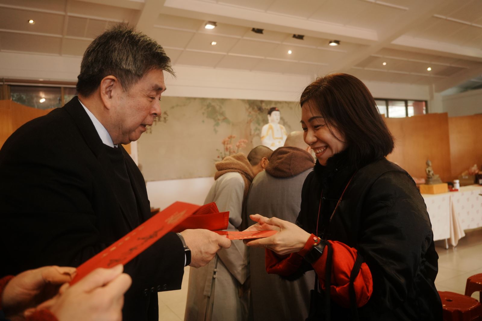 教職同仁高興接過李天任校長（左）代董事長發的紅包。