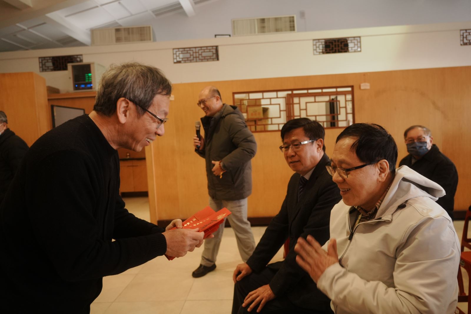 教職同仁高興接過簡江儒教務長（左）代董事長發的紅包。