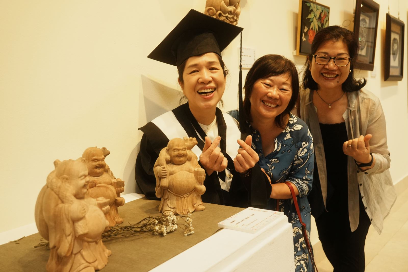 佛藝系秦碧雲同學（左）與其他同學合力完成的木雕作品〈賜福彌勒〉。